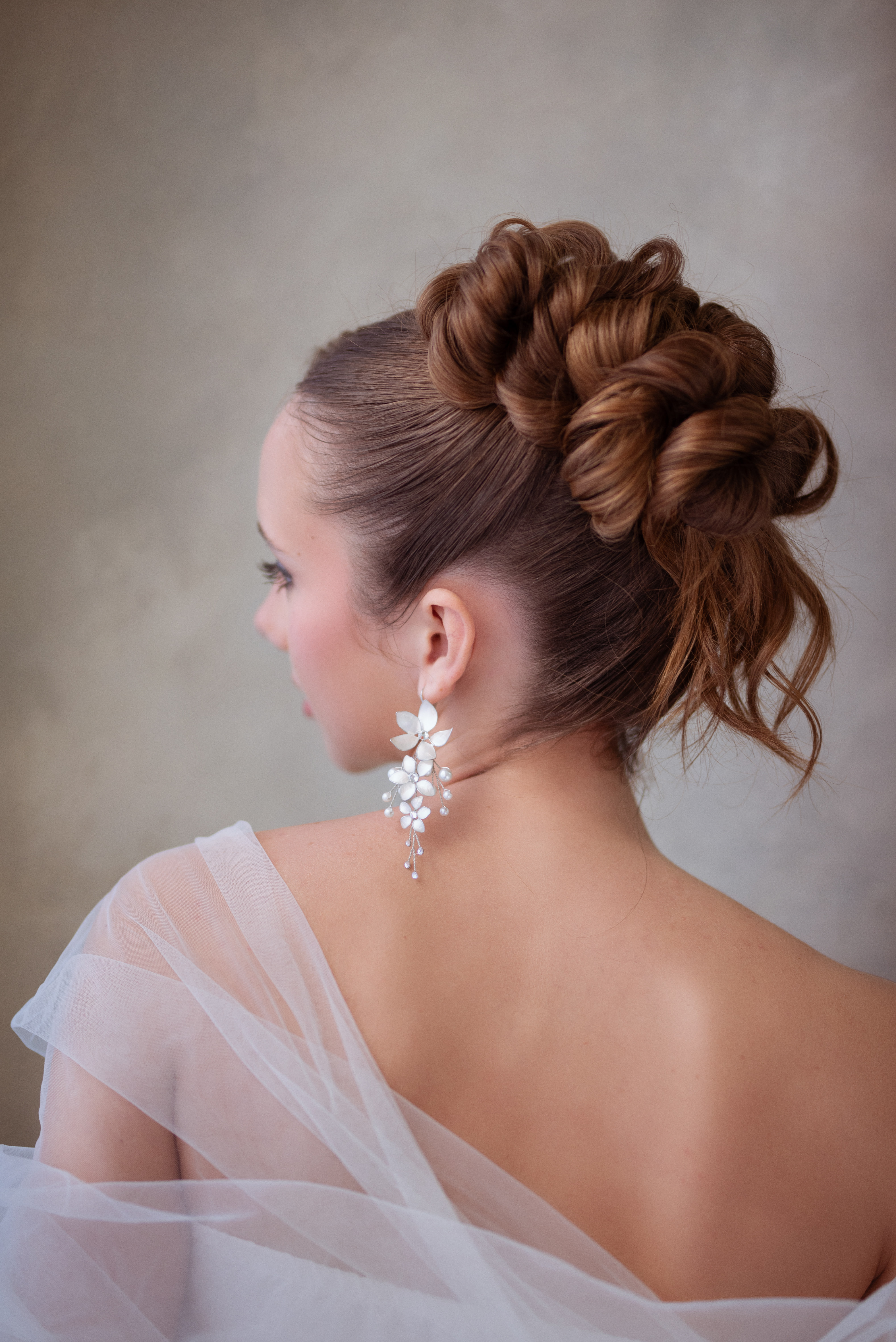 Recogido de novia con moños y pendientes florales realizado por Natali Hairstyles
